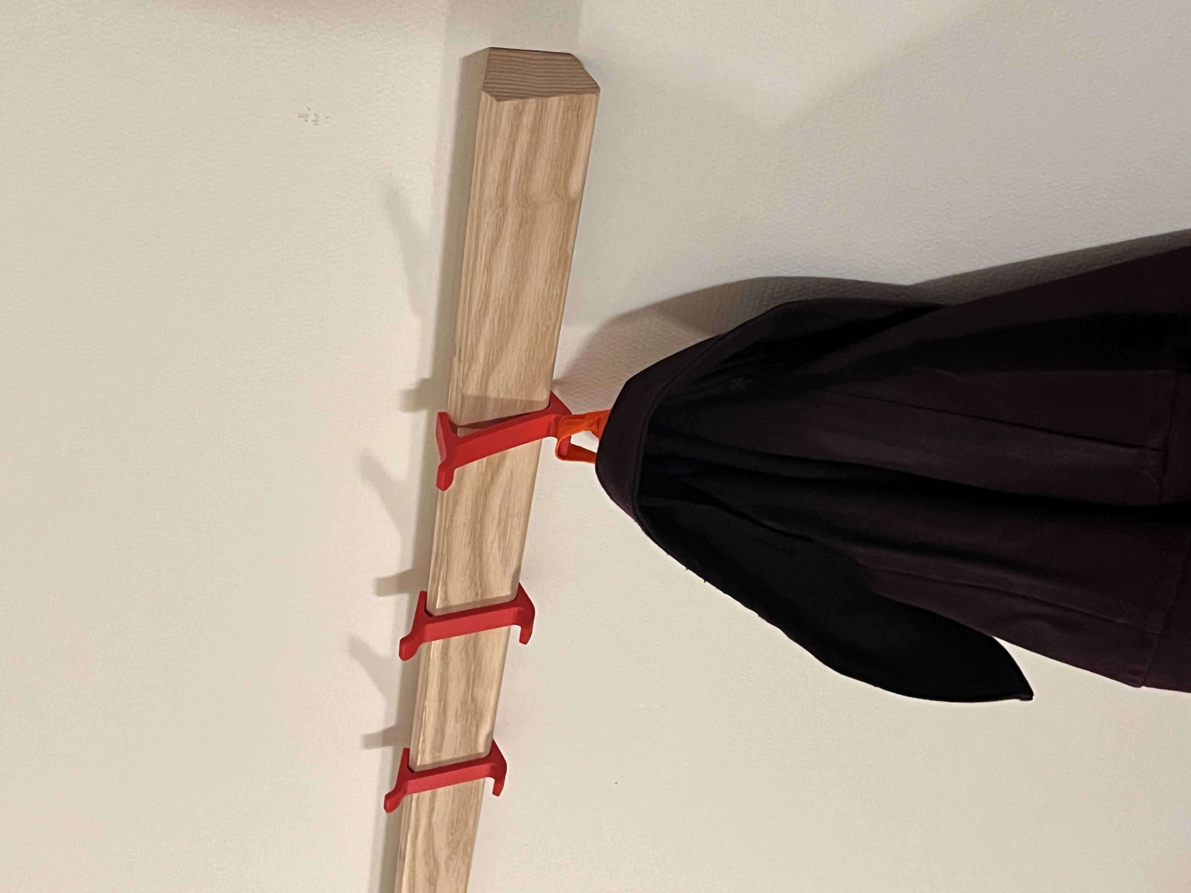 Mansarde — Garderobe mit Bilderleiste und roten Haken, Sideboard darunter