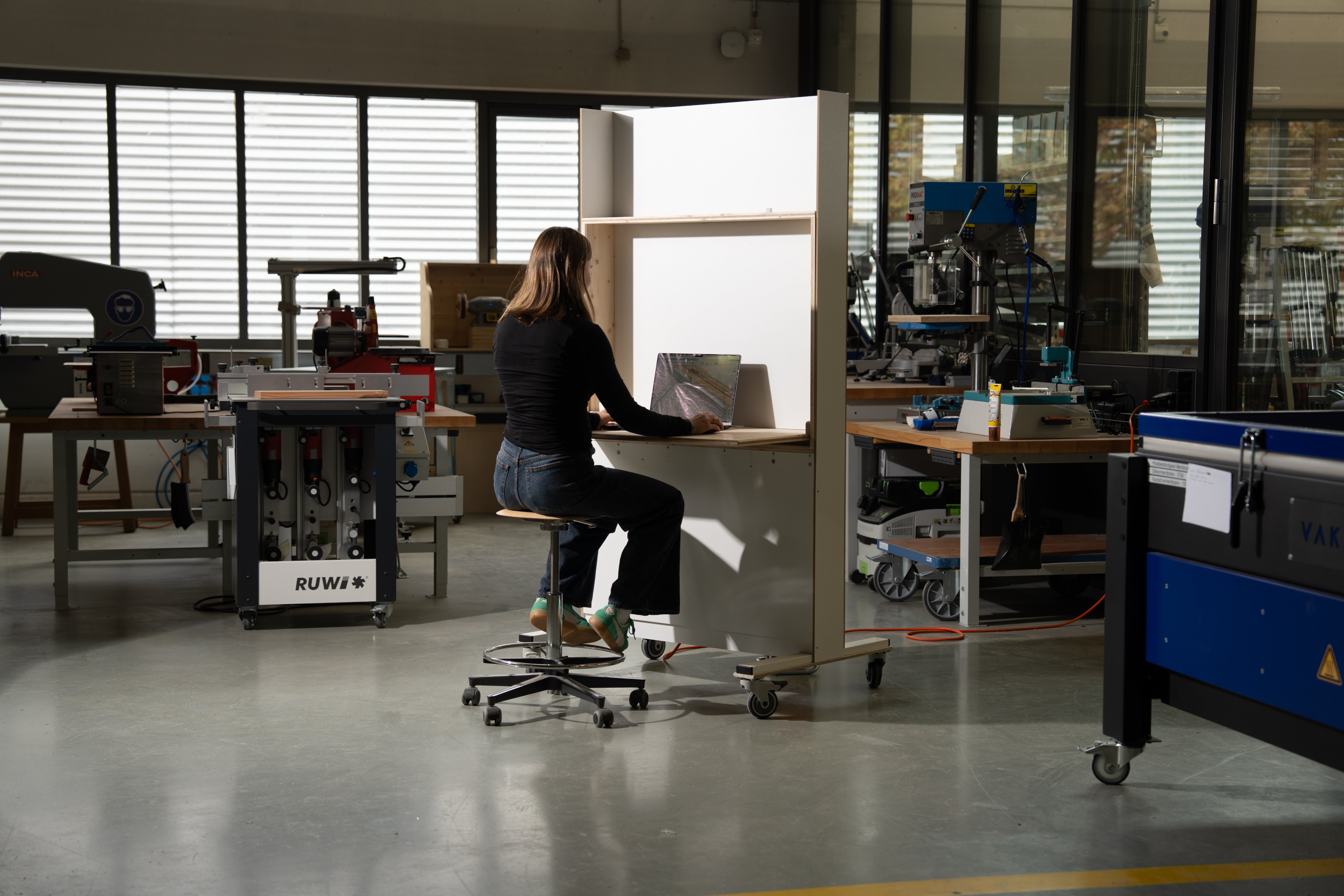 Flying Desk — Person sitzt am Schreibtisch in der Werkstatt