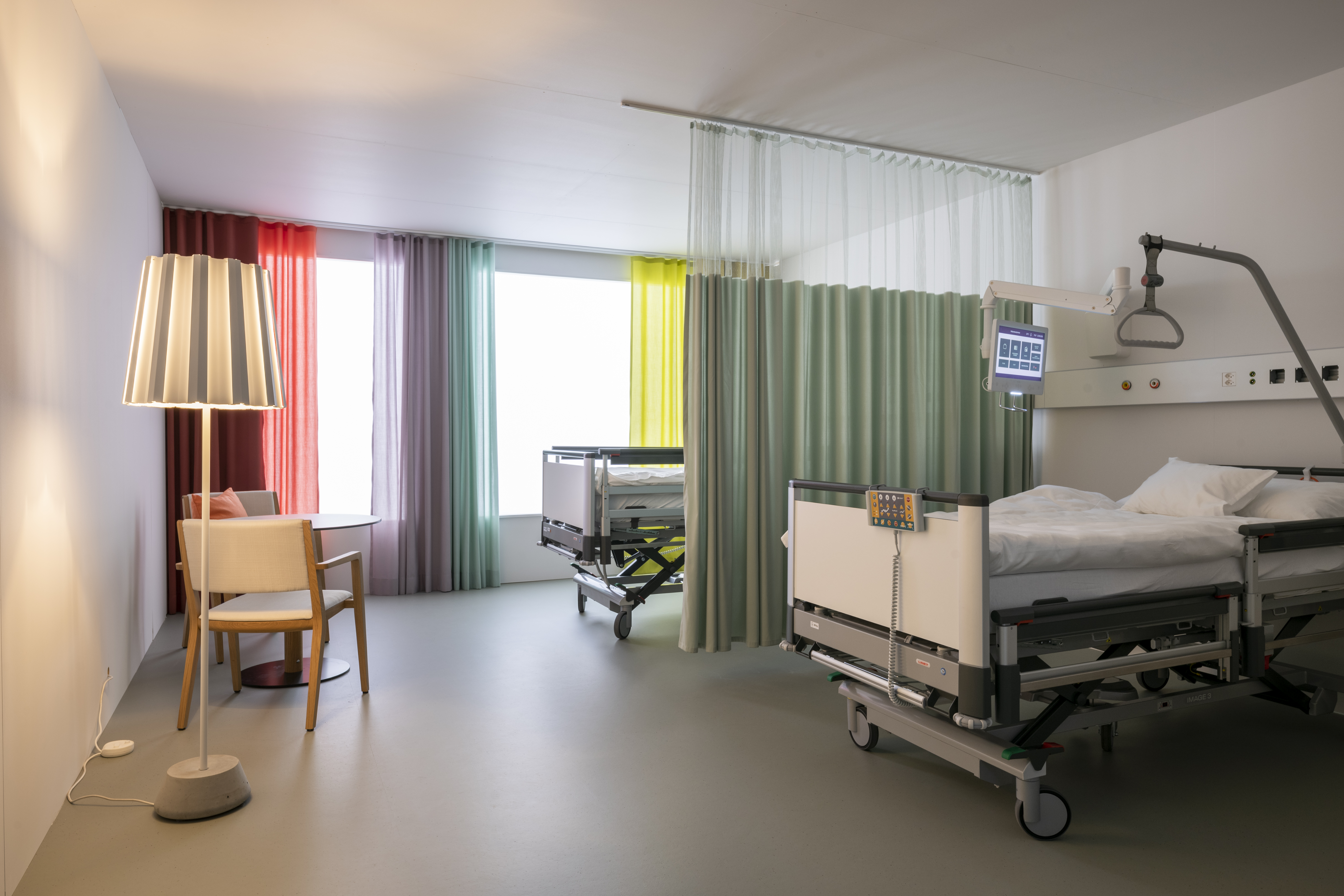 SCDH Testräume — Krankenzimmer mit farbigen Vorhängen und Spitalbett